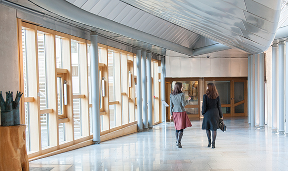 Two females walking through the Scottish Parliament