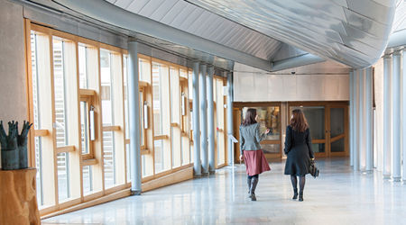 Two females walking through the Scottish Parliament