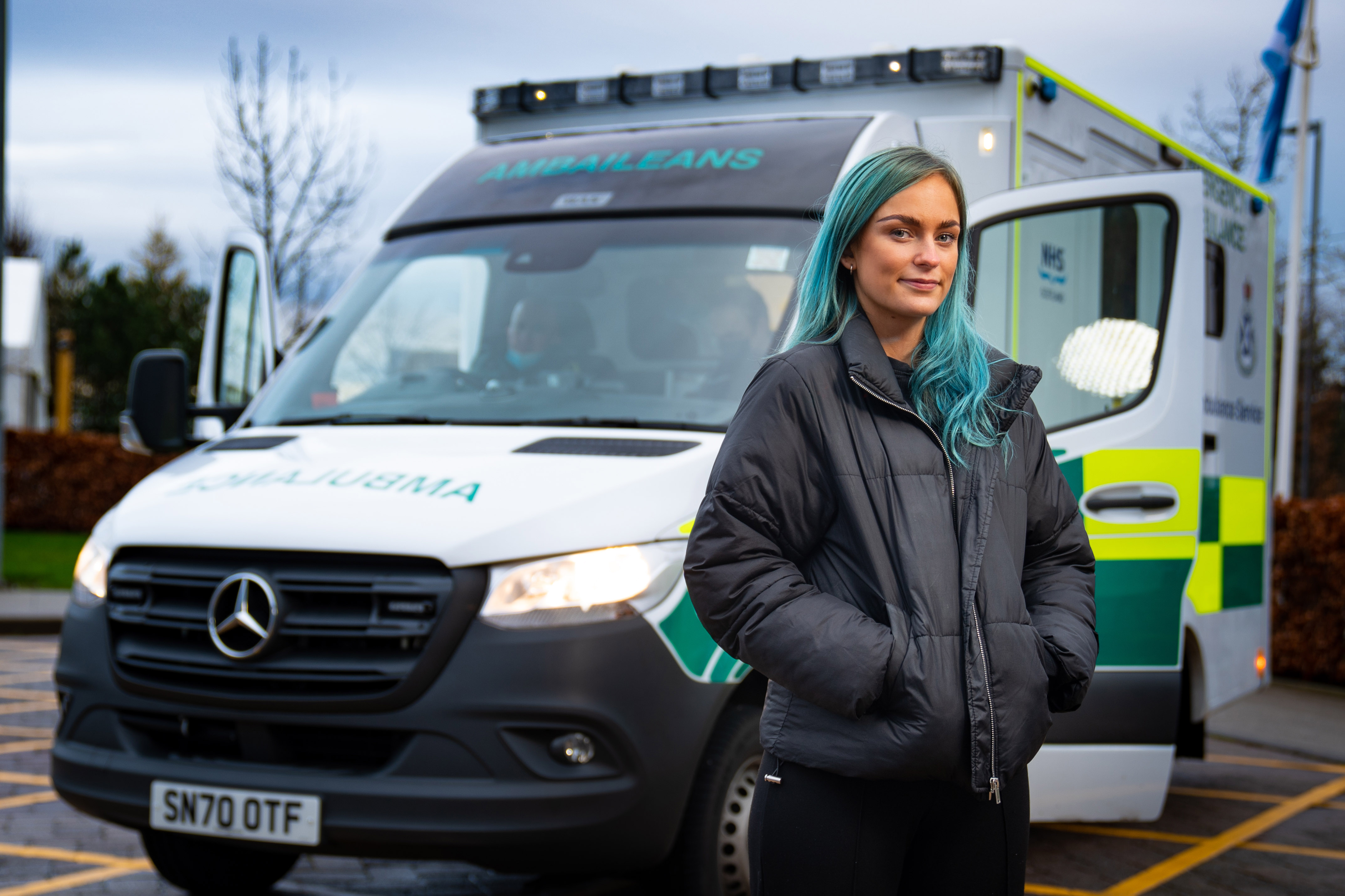 Paramedic Science student standing beside and ambulance