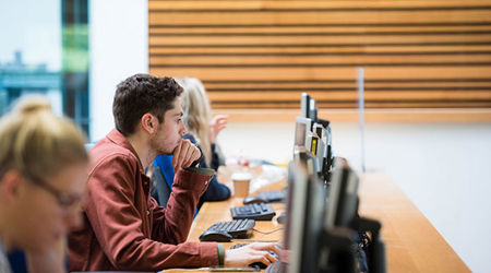 Row of Queen Margaret University students working on desktop computers