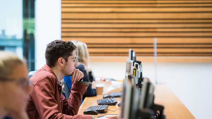 Row of Queen Margaret University students working on desktop computers