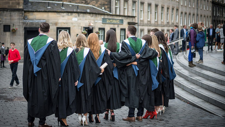 A row of QMU graduands standing in a row wearing their gowns outside Usher Hall