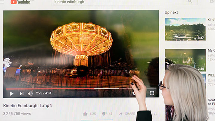 Student presenting video of illuminated carousell ride 