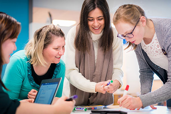 Four students working on a group project poster together
