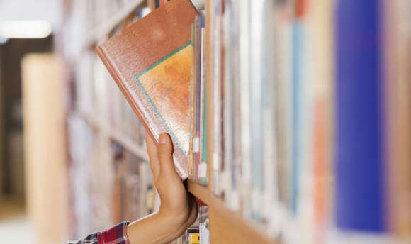 Bookshelf with book being pulled off it 