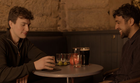 Two men enjoying a beer in a dimly lit pub