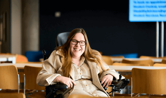 Female student on wheelchair smiling at the camera