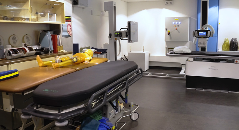 A wide shot of one of the radiography rooms, various pieces of medical equipment are shown throughout