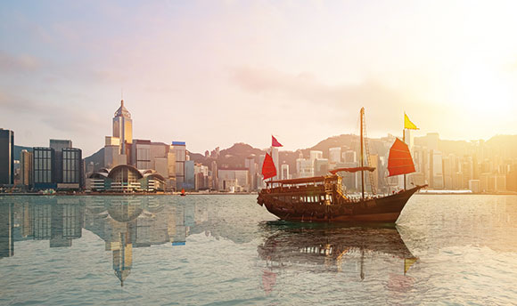 Istock photo of Hong Kong skyline with red sailed Junk in bay