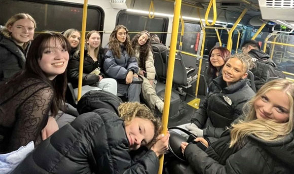 A large group of young people riding a bus.