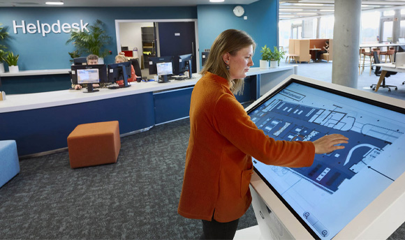 A young woman using a large, free-standing touch screen device.