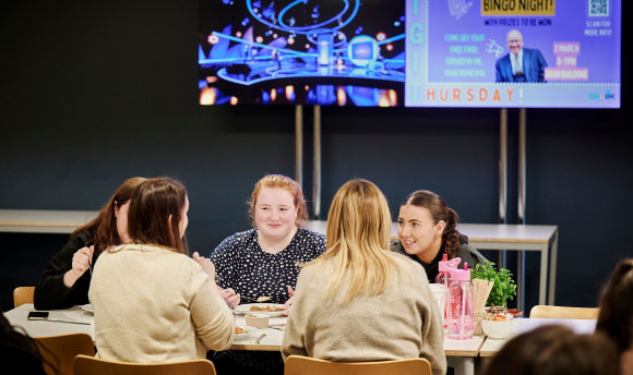 A group of QMU students sat around a table