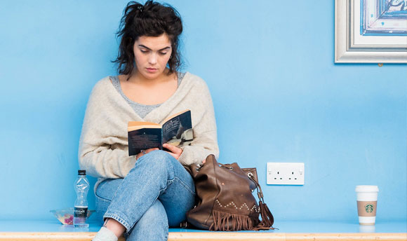 Student reading on a bench
