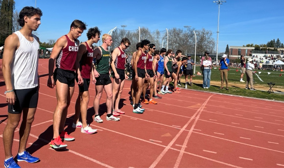 A row of runners lined up at the start of a racetrack