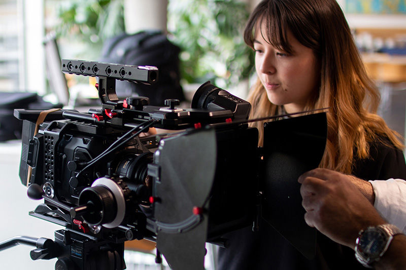 A female student operates a high-end digital film camera