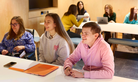 students smiling while working in the library