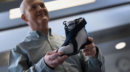 Derek Santos holding an innovative design for a shoe which helps those with footdrop