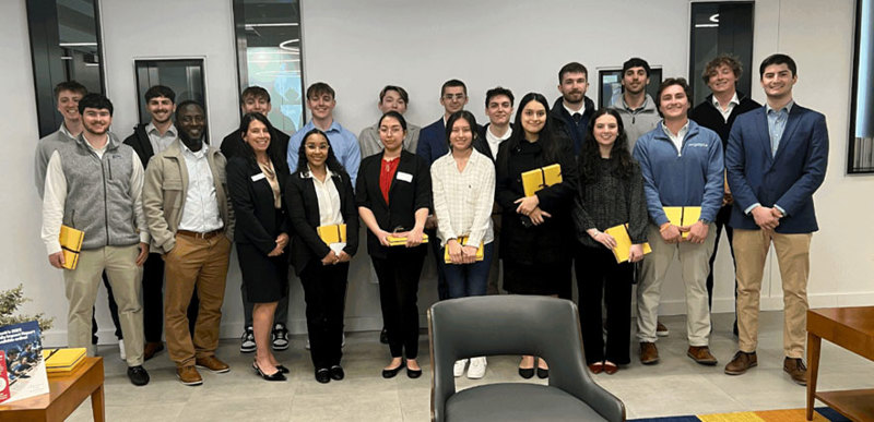 A large group of people wearing smart uniforms pose for a photo together.