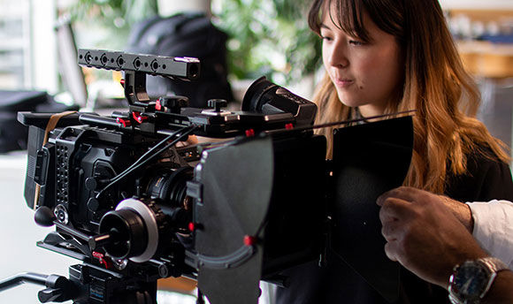 A female student operates a high-end digital film camera