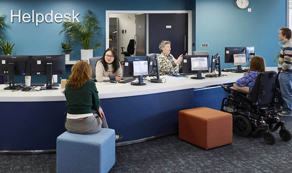 Several students speaking to staff members at the LRC Helpdesk