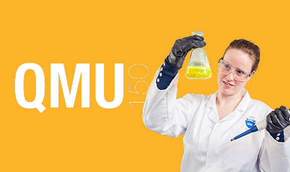 A scientist holding aloft a flask filled with a bright yellow liquid
