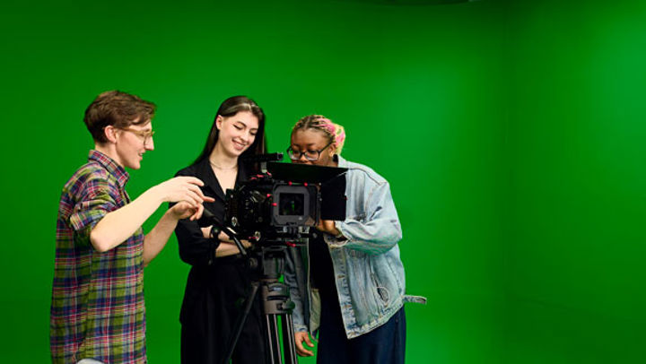 Students using a camera and green screen