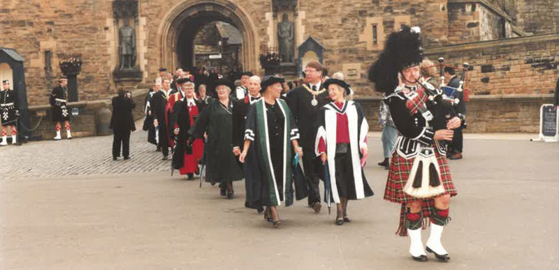 Members of staff from Queen Margaret University follow a piper in a procession down Edinburgh's Royal Mile as part of the university's 125th anniversary celebrations.
