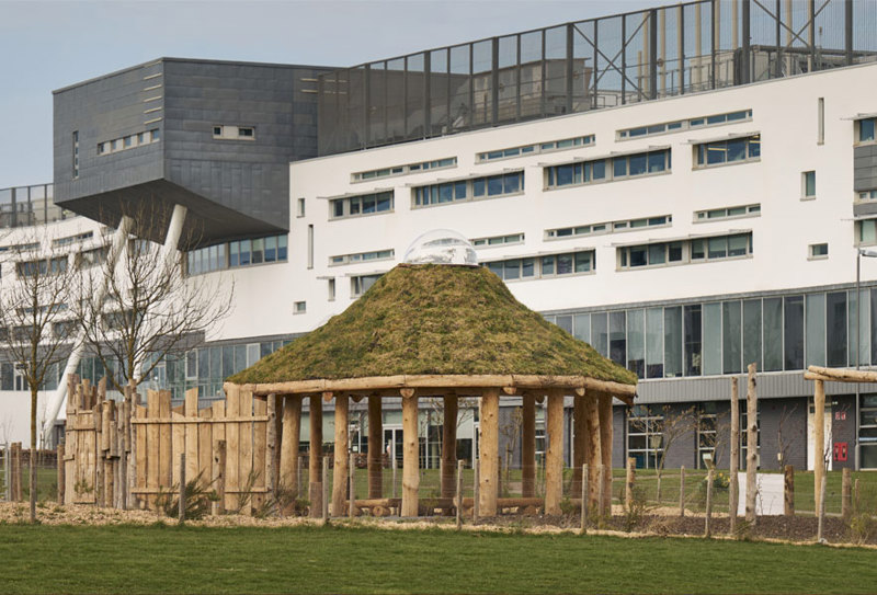 A thatched roof with a plastic dome in the centre sits atop a wooden structure.