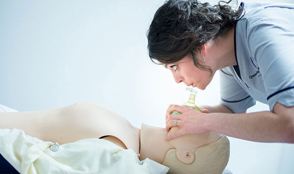 QMU student nurse practicing CPR on a Resusci Annie doll