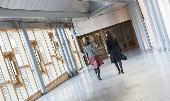 Two women walking down a corridor