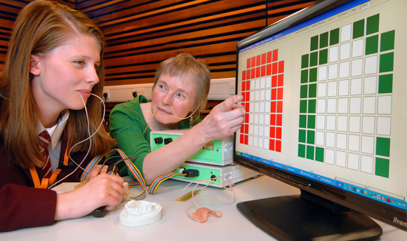 A student & Lecturer with probes in their mouths looking at a screen covered in coloured squares