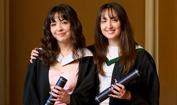 Sisters Rachel And Jessica Thorpe in graduation gowns