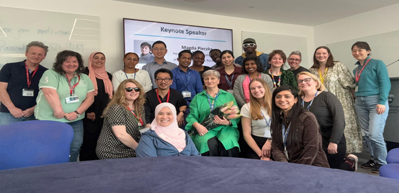A group of people posing for a photo inside a conference suite.