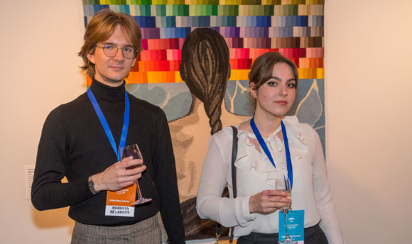Two students standing in front of some artwork at Dovecot studios