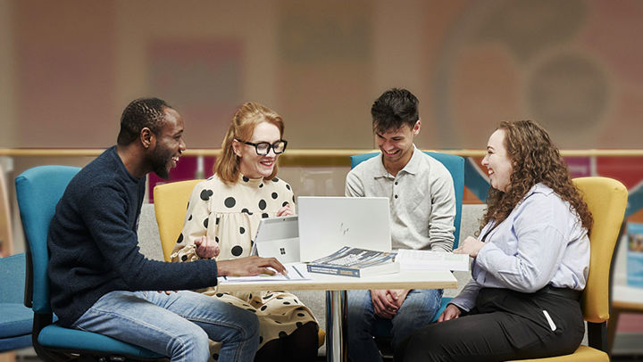 Happy colleagues chatting and working around a desk