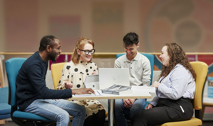 Happy colleagues chatting and working around a desk