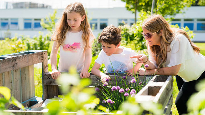Teacher and young children in a community garden